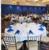Banquet table with white tablecloth and blue napkins set in Stillings Hall